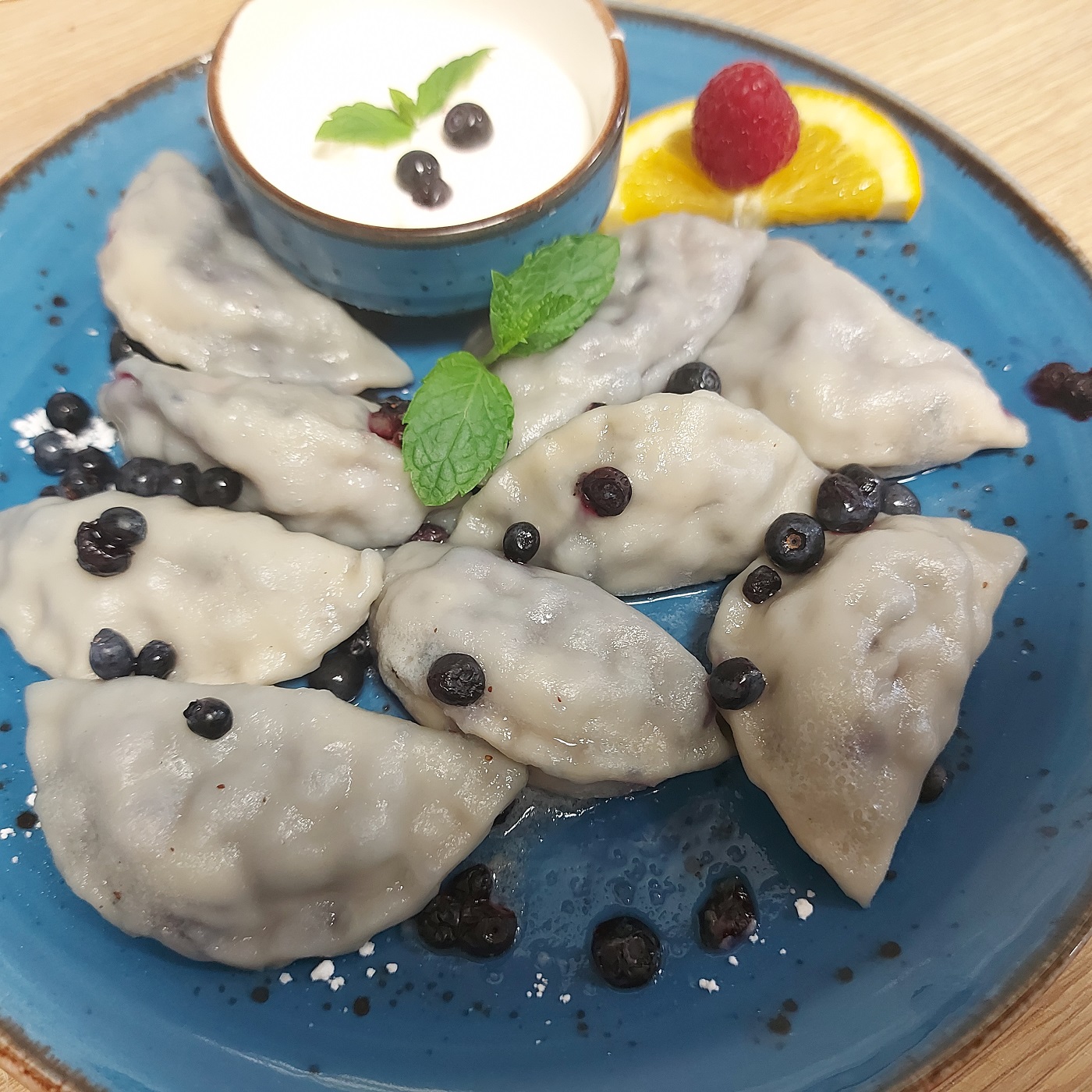 Pierogi z jagodami na niebieskim talerzu